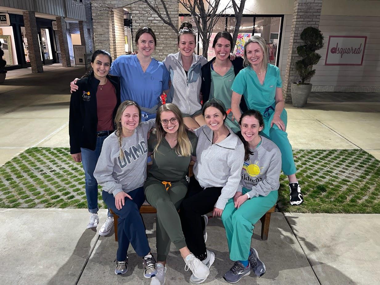 group picture of nine pediatric residents at outdoor mall